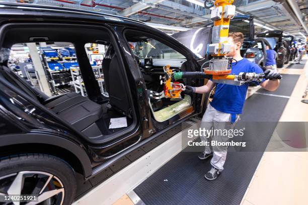 An employees fixes the seats of a Volkswagen AG ID.5 electric sports utility vehicle on the assembly line at the automaker's electric automobile...