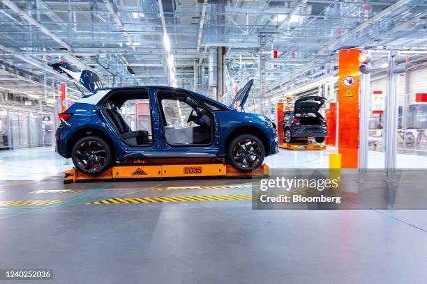 An automated guided vehicle moves a Seat Cupra Born electric vehicle on the assembly line at the Volkswagen AG electric automobile plant in Zwickau,...