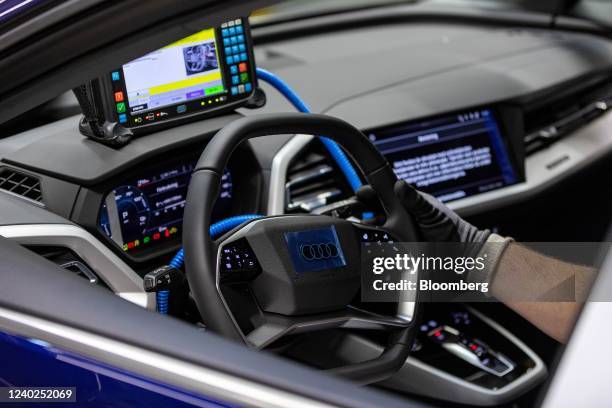 An employee runs a diagnostic test on an Audi Q4 e-tron electric vehicle on the assembly line at the Volkswagen AG electric automobile plant in...