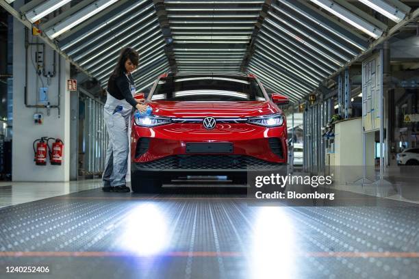 An employee conducts quality control checks on a Volkswagen AG ID.5 electric sports utility vehicle in the light tunnel of the assembly line at the...