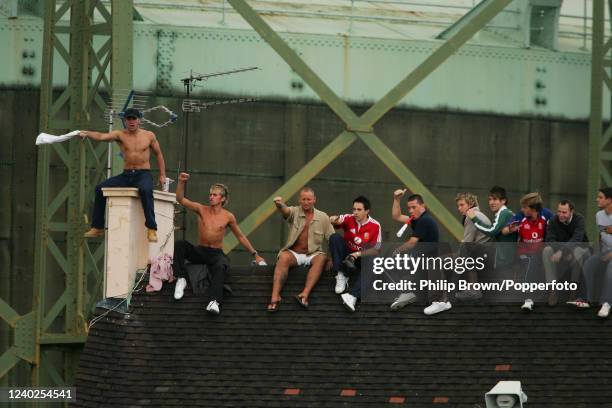 Spectators find a vantage point on the rooftop of the former Cricketers Pub outside the ground on day five of the 5th Test match between England and...