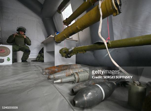 Minesweeper of National Guard of Ukraine sits next to weapons left by Russian troops in Chernobyl zone, during an exhibition in Chernobyl on April...