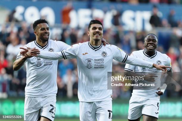 Joel Piroe of Swansea City celebrates his second goal with Cyrus Christie and Michael Obafemi during the Sky Bet Championship match between Swansea...