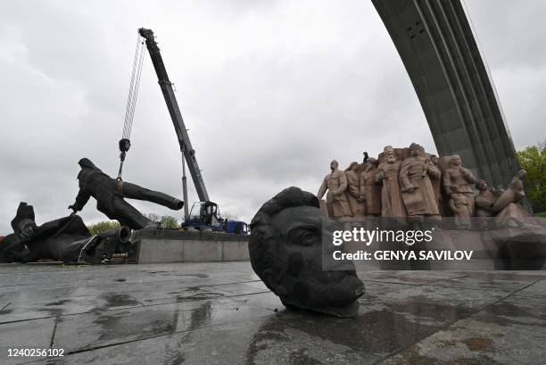 This photograph taken on April 26, 2022 shows the Soviet monument to Ukraine-Russia friendship being dismantled in Kyiv. - Authorities in Kyiv on...