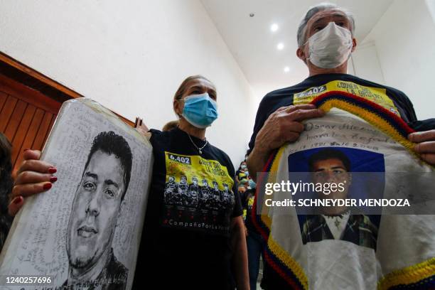 Relatives of a victim hold posters with his portrait during a hearing organized by the Special Jurisdiction for Peace in Ocana, Colombia, on April...