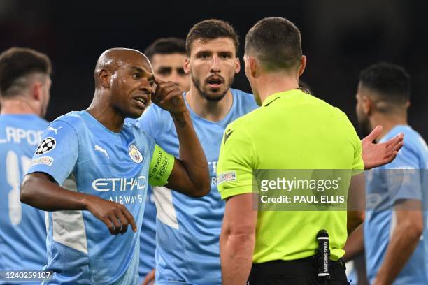 Manchester City's Brazilian midfielder Fernandinho and Manchester City's Portuguese defender Ruben Dias argue with Romanian referee Istvan Kovacs for...