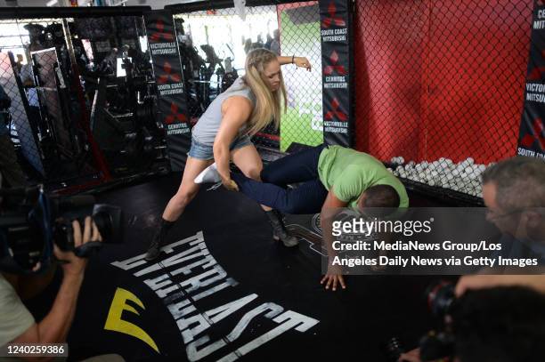 Glendale, CA UFC Bantamweight Champion Ronda Rousey demonstrates an ankle pick on NBC's Craig Melvin for the Today Show at the Glendale Fighting Club...