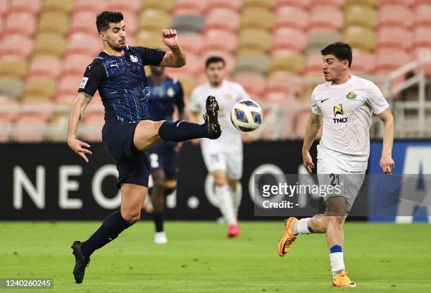 Gharafa's midfielder Saeid Ezatolahi vies for the ball with Ahal's midfielder Resul Hojayev during the AFC Champions League group C match between...