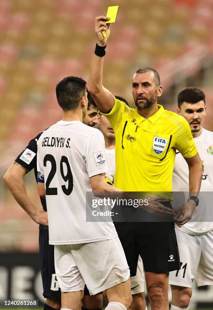 Lebanese referee Ali Reda presents a yellow card to Ahal's midfielder Serdar Geldiyew during the AFC Champions League group C match between...