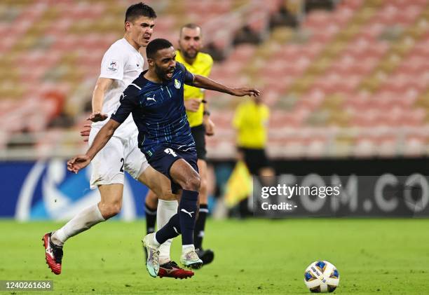 Gharafa's midfielder Moayad Hassan is tackled by Ahal's midfielder Serdar Geldiyew during the AFC Champions League group C match between...