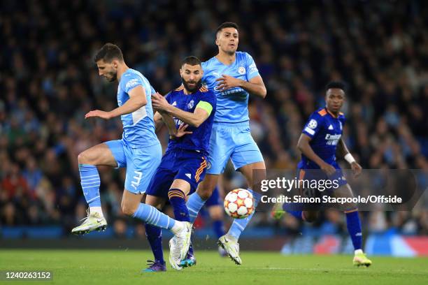 Karim Benzema of Real Madrid battles with Ruben Dias of Manchester City and Rodri of Manchester City during the UEFA Champions League Semi Final Leg...