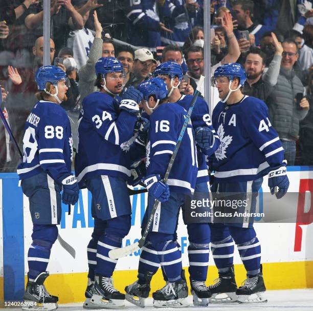 Auston Matthews of the Toronto Maple Leafs celebrates his 60th goal of the season with teammates during an NHL game against the Detroit Red Wings at...