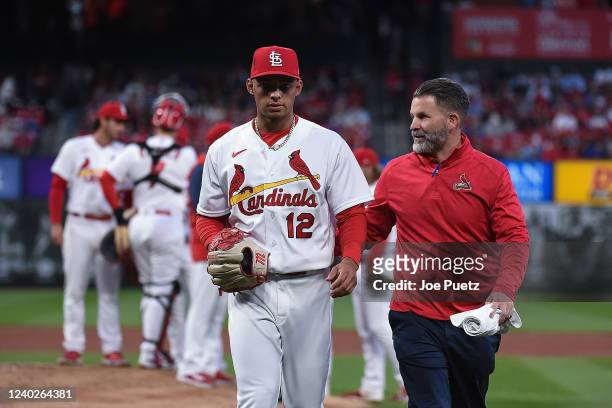 Jordan Hicks of the St. Louis Cardinals walks to the dug out with training staff after being removed from the game against the New York Mets during...