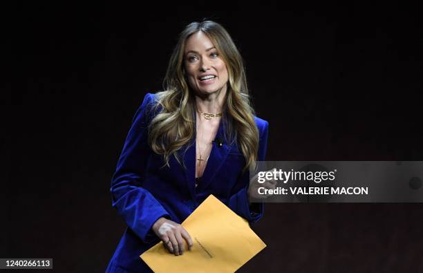 Director and actress Olivia Wilde holds an envelope reading "personal and confidential" as she speaks onstage during the Warner Bros. Pictures "The...