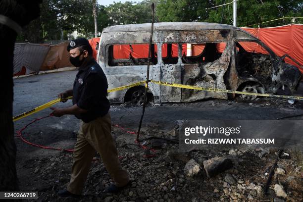 Police adjusts crime scene barricade tape at the blast site a day after a suicide attack on a van near the Confucius institute which is the cultural...