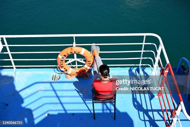 Ukrainian woman looks at her smartphone on a deck of the Corsica Linea ferry "Mediterranee" in Marseille, southern France, on April 26, 2022. - Anna...