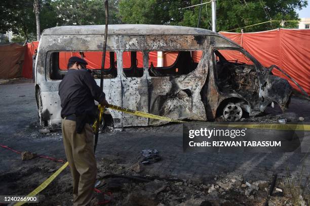 Police adjusts crime scene barricade tape at the blast site a day after a suicide attack on a van near the Confucius institute which is the cultural...