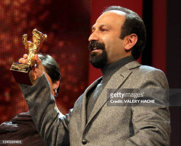 Iranian director Asghar Farhadi celebrates with his golden bear for "Best film" for his movie "Jodaeiye Nader az Simin" during the awards ceremony of...