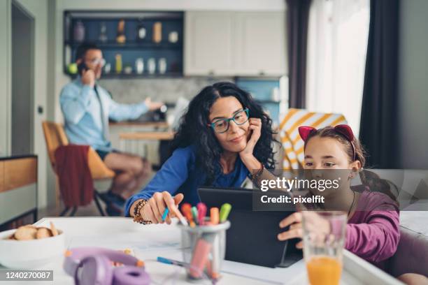 family with a schoolgirl homeschooling and working at home - mother child homework stock pictures, royalty-free photos & images