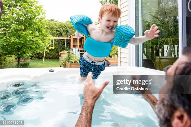 cute kid and father in the hot tub in the backyard in summer - whirlpool stock pictures, royalty-free photos & images