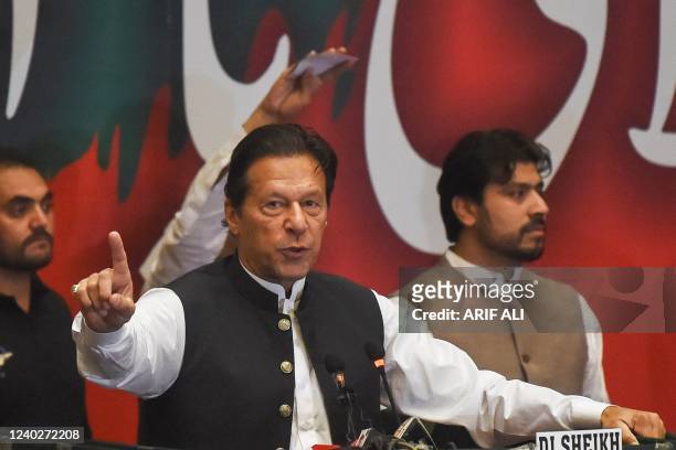 Former Pakistan's prime minister Imran Khan, who was ousted by opposition parties through a no-confidence motion, gestures as he addresses Pakistan...
