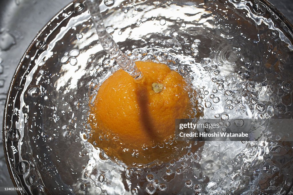 Orange in a ball with water splash