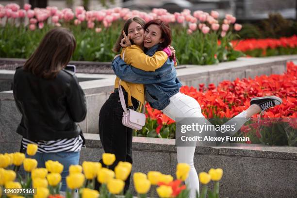 Young women pose for a photo among tulips in blossom on Independence Square on April 27, 2022 in Kyiv, Ukraine. Following Russia's retreat from areas...