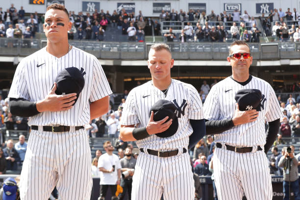 Members of the New York Yankees during the national anthem prior to the game between the Boston Red Sox and the New York Yankees at Yankee Stadium on...