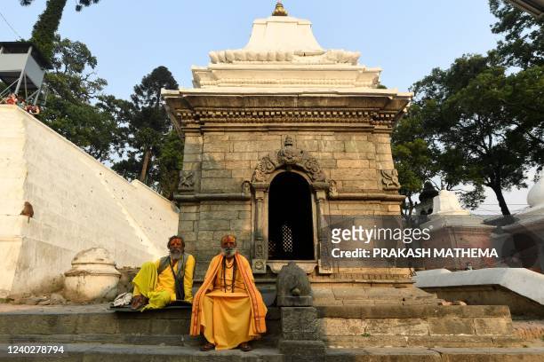 Sadhus or Hindu holy men pose for picture at the Pashupatinath temple area in Kathmandu on April 27, 2022.