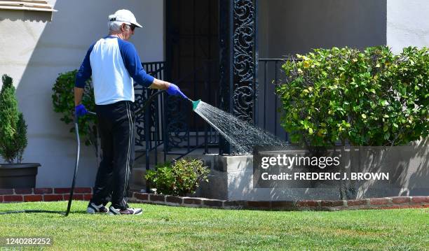 Man waters his lawn in Alhambra, California on April 27 a day after Southern California delared a water shortage emergency, with unprecedented new...