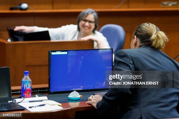 Actor Johnny Depp chats with the court stenographer during a break amid his defamation trial against his ex-wife Amber Heard, at the Fairfax County...