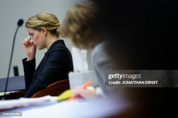 Actor Amber Heard reacts as a pre-recorded deposition testimony of Christian Carino is played during her ex-husband Johnny Depp's defamation trial...