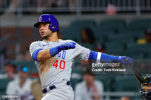 Willson Contreras of the Chicago Cubs hits a double to bring in a run during the tenth inning of an MLB game against the Atlanta Braves at Truist...
