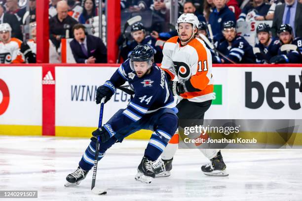 Josh Morrissey of the Winnipeg Jets plays the puck away from Travis Konecny of the Philadelphia Flyers during second period action at the Canada Life...