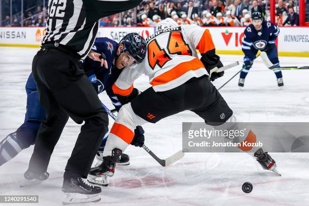 Adam Lowry of the Winnipeg Jets battles Nate Thompson of the Philadelphia Flyers off a second period face-off at the Canada Life Centre on April 27,...