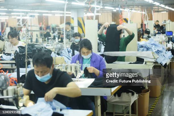 People work in a garment factory in Hangzhou in east China&#039;s Zhejiang province Wednesday, April 27, 2022.