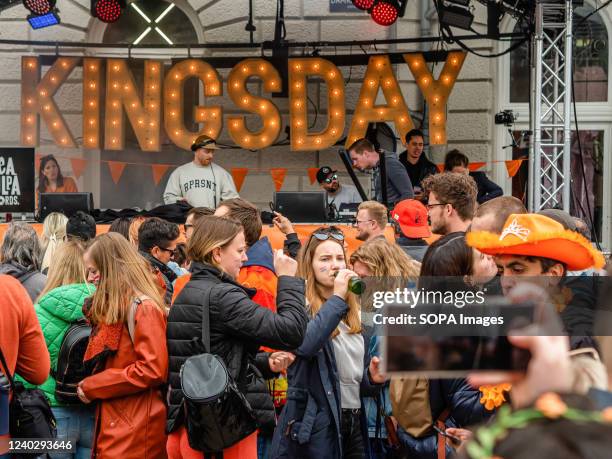 People are enjoying the music of a DJ playing on the street. After two years of restrictions, this year's King's Day celebrations went back to...