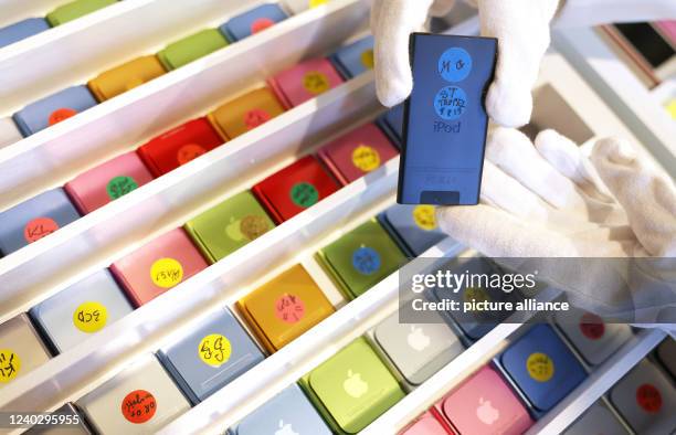 April 2022, North Rhine-Westphalia, Cologne: Felicitas, an employee of Sotheby's auction house, holds an iPod by Karl Lagerfeld. Personal items of...