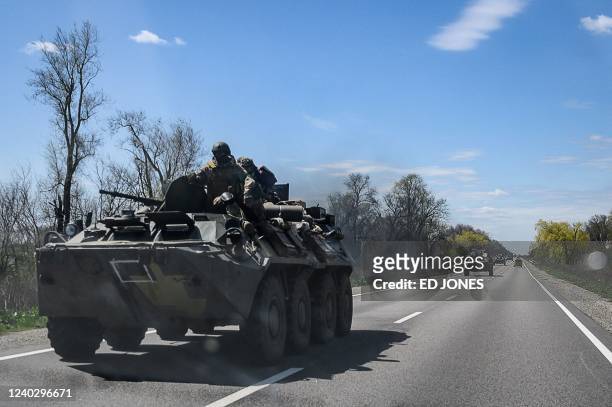 Ukrainian servicemen ride on an armoured personnel carrier as they make their way along a highway on the outskirts of Kryvyi Rih on April 28 amid...