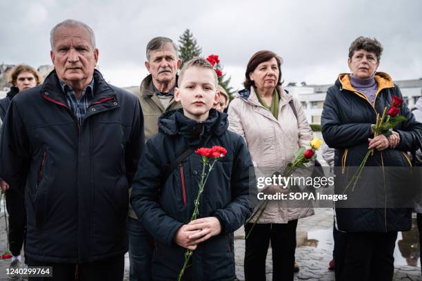 Young boy stands with his relatives while holding a carnation flower during the 36th anniversary of Chernobyl disaster. The 36th anniversary of the...