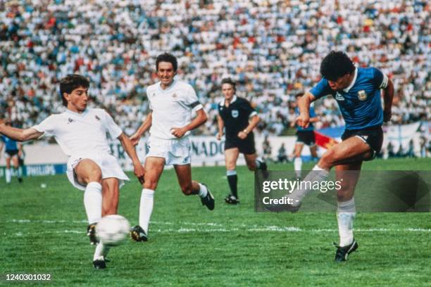 Argentina's player Diego Maradona hits the ball while his Uruguayan opponents Jorge Da Silva and Jorge Barrios try to block him during the match...