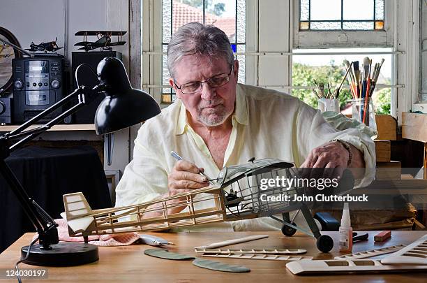 middle aged model maker - man sitting at a desk craft stockfoto's en -beelden