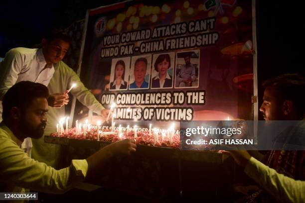 Members of the Peoples Students Federation place candle to pay tribute to Chinese teachers who were killed in a suicide blast in Karachi on April 28,...