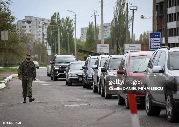 Transnistrian serviceman walks past a line of car queuing to exit the self-proclaimed "Moldovan Republic of Transnistria" at Varnita border point...