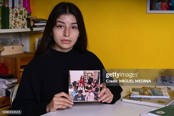 Years-old Ukrainian refugee Yana Alieva, from Kharkiv, shows a picture of her with her Ukrainian friends, in Milan on April 26, 2022 in the home of...