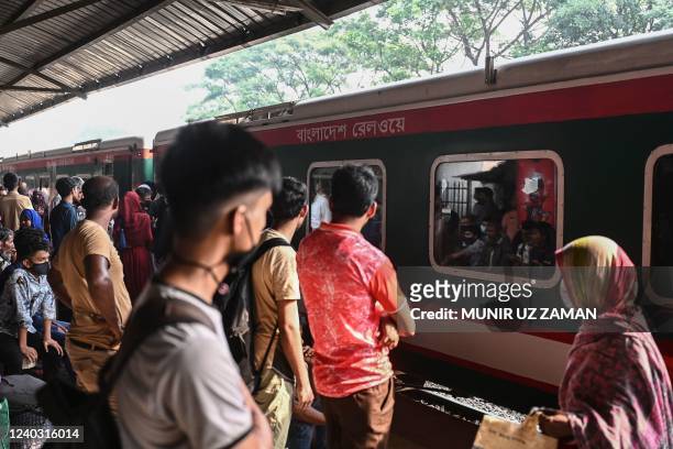 People returning home to celebrate Eid al-Fitr festival, which marks the end of Islam's Holy fasting month of Ramadan, wait on a platform to board a...