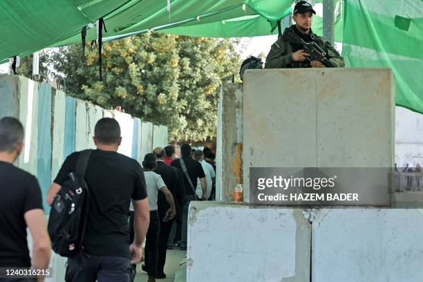Israeli security forces keep watch as Palestinians cross a checkpoint to reach the city of Jerusalem to attend the last Friday prayers of Ramadan in...