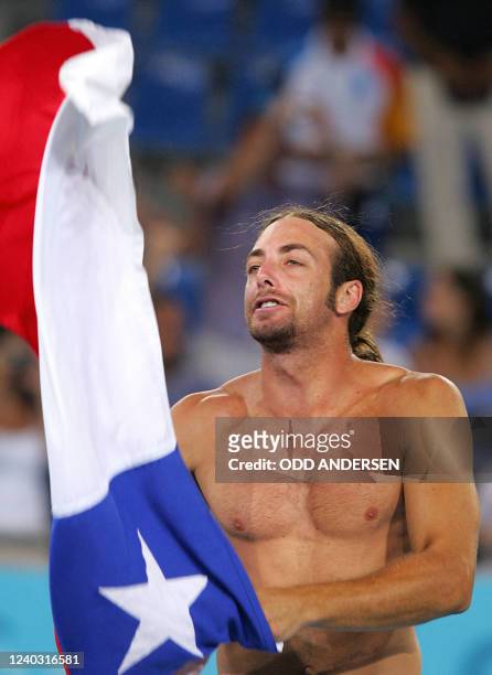 Nicolas Massu of Chile waves his flag after he and teammate Fernando Gonzalez defeated their German opponents Rainer Schuettler and Nicolas Kiefer in...