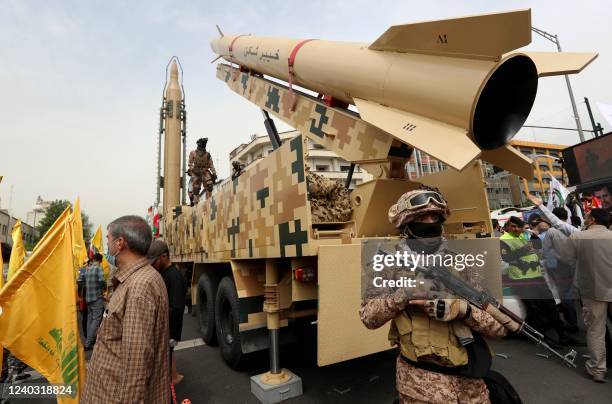 Iranian soldiers stand next to an Iranian Kheibar missile and a Shahab-3 missile during a rally marking al-Quds day, in street at the capital Tehran,...