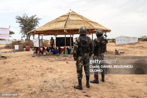 Soldiers look on as a group of children take part in a reading lesson given by an NGO during a field visit by Filippo Grandi, the United Nations High...